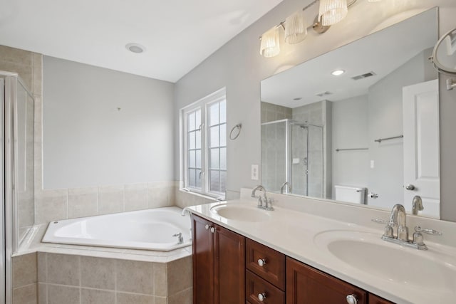 full bathroom featuring vanity, separate shower and tub, and toilet