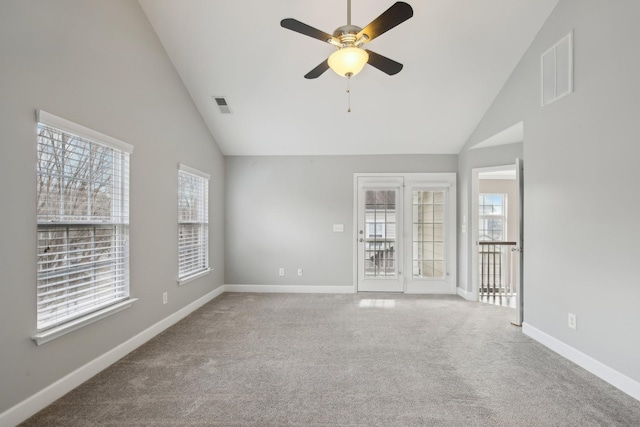 carpeted empty room with ceiling fan and high vaulted ceiling