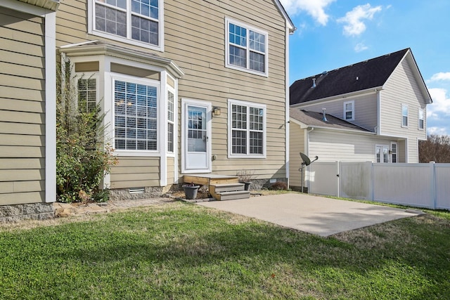 rear view of property with a lawn and a patio