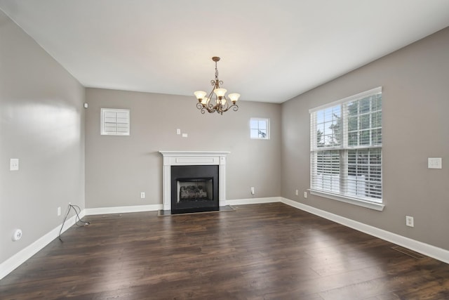 unfurnished living room with a chandelier and dark hardwood / wood-style floors