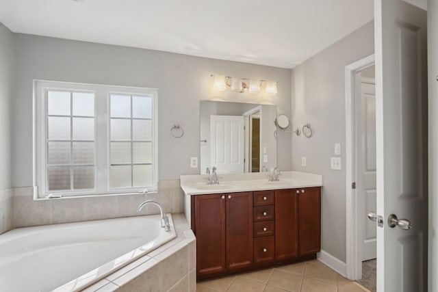 bathroom featuring tile patterned flooring, vanity, and tiled tub