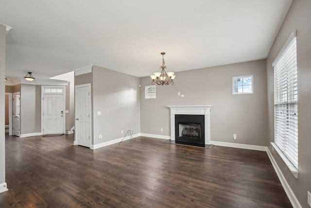 unfurnished living room with dark wood-type flooring and an inviting chandelier