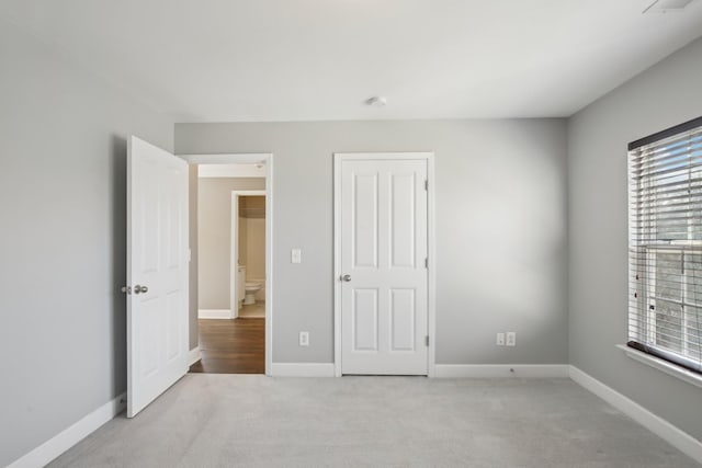 unfurnished bedroom featuring light carpet