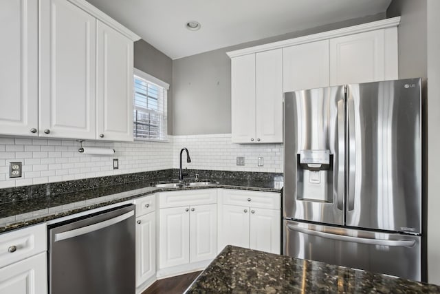 kitchen featuring dark stone countertops, white cabinetry, and stainless steel appliances