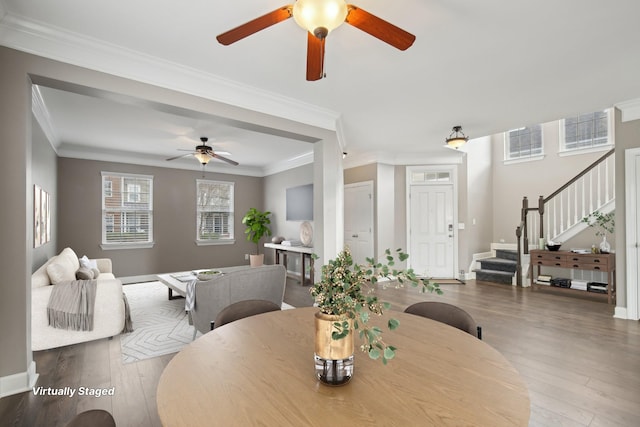 dining area with wood-type flooring and crown molding