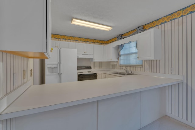 kitchen with white cabinets, sink, white appliances, and kitchen peninsula