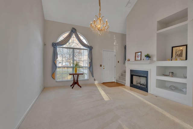 unfurnished living room featuring built in shelves, lofted ceiling, carpet floors, and a chandelier