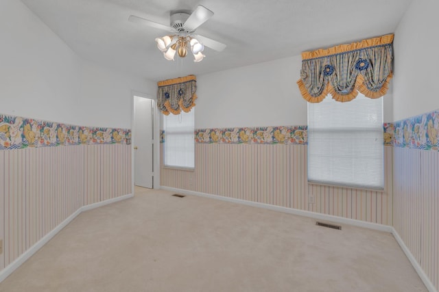 unfurnished room featuring carpet, ceiling fan, and a healthy amount of sunlight