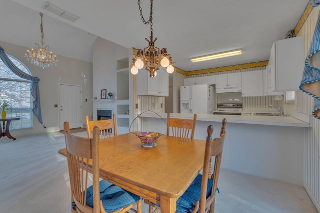 carpeted dining room with sink and an inviting chandelier