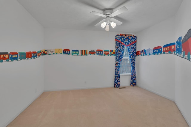 carpeted spare room featuring ceiling fan