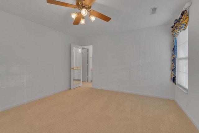 spare room featuring ceiling fan and light carpet