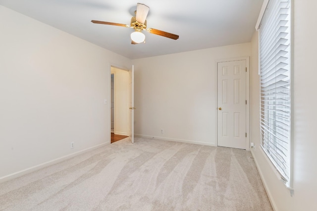 empty room with ceiling fan and light colored carpet