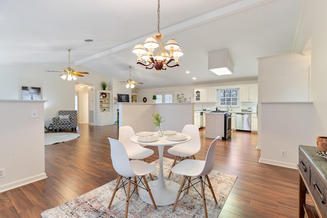 dining area with dark hardwood / wood-style flooring, lofted ceiling with beams, and ceiling fan with notable chandelier