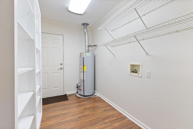 clothes washing area featuring hookup for a washing machine, crown molding, dark hardwood / wood-style flooring, and gas water heater