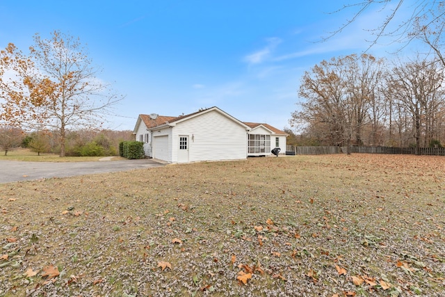 view of side of home with a lawn and a garage