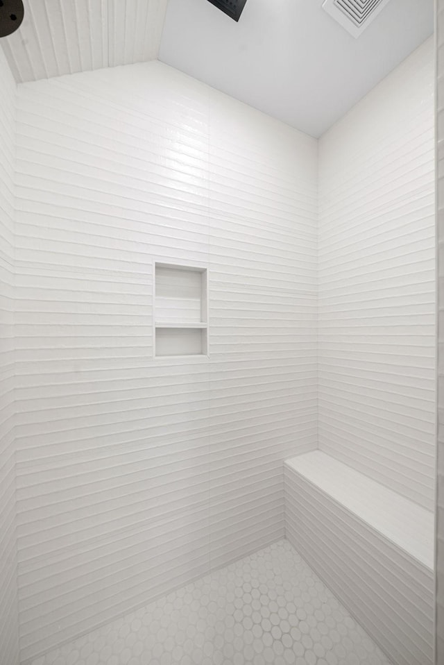 bathroom featuring a shower and lofted ceiling