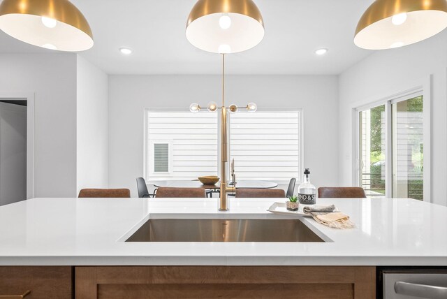 kitchen featuring pendant lighting, a center island with sink, and sink