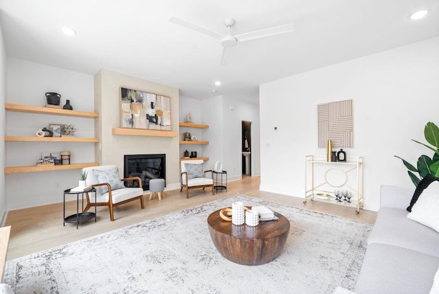 living room featuring light hardwood / wood-style flooring and ceiling fan