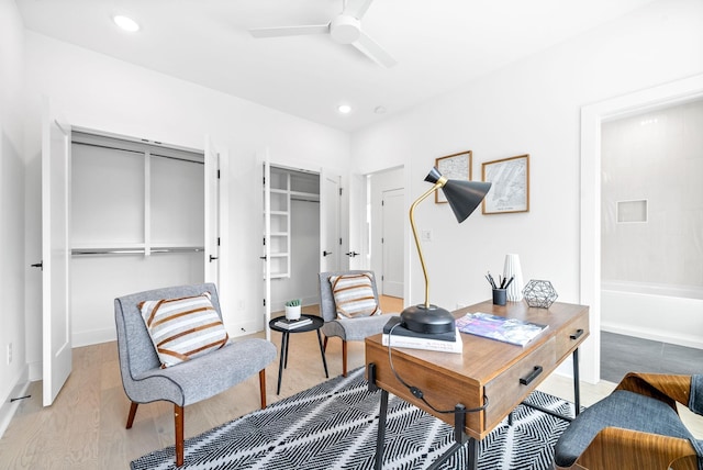 home office with ceiling fan and light hardwood / wood-style flooring