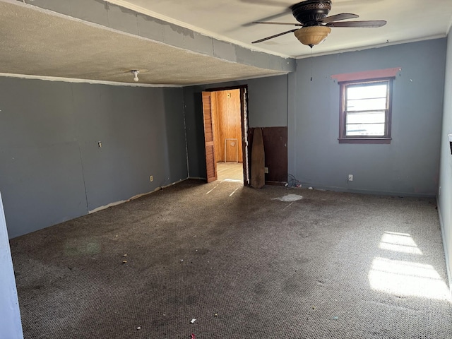 spare room featuring carpet flooring, ceiling fan, and a textured ceiling