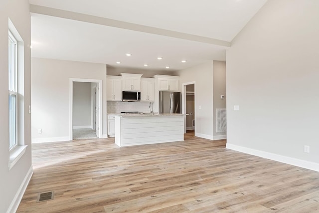 unfurnished living room featuring sink and light wood-type flooring