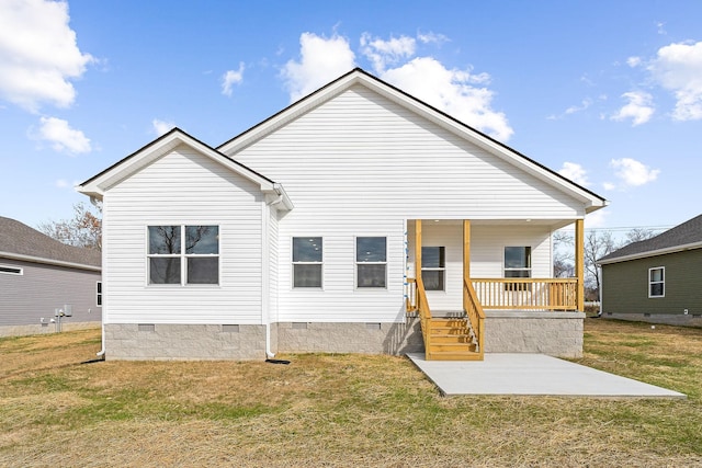 back of house with covered porch and a yard