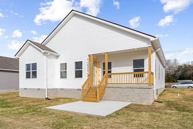 rear view of property featuring a lawn and a porch