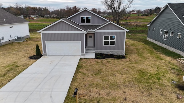 view of front facade with a garage, central air condition unit, and a front yard