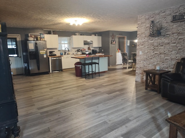 living room with hardwood / wood-style floors, a healthy amount of sunlight, and a textured ceiling