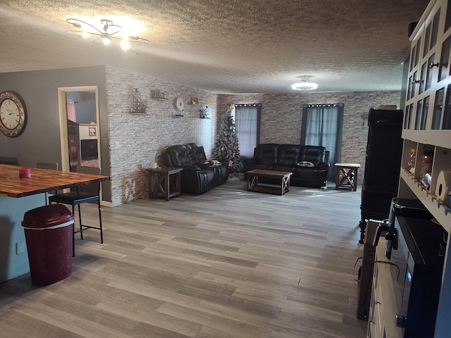 living room featuring wood-type flooring and a textured ceiling