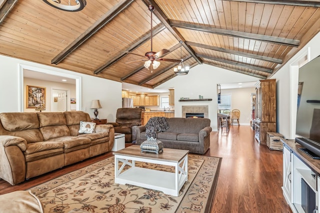 living room featuring beamed ceiling, wooden ceiling, dark wood-type flooring, and a tiled fireplace