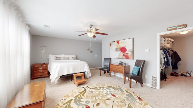 carpeted bedroom featuring ceiling fan, a closet, and a spacious closet