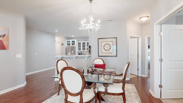 dining space featuring dark hardwood / wood-style flooring and an inviting chandelier