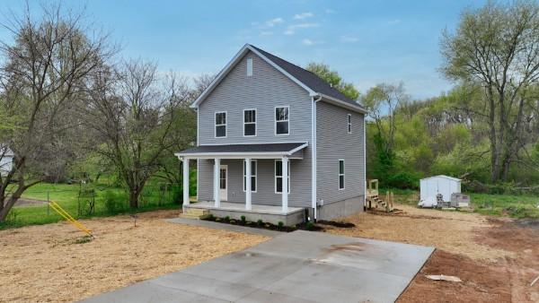 view of front of home with covered porch and a storage unit