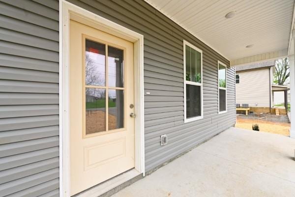 view of exterior entry featuring covered porch