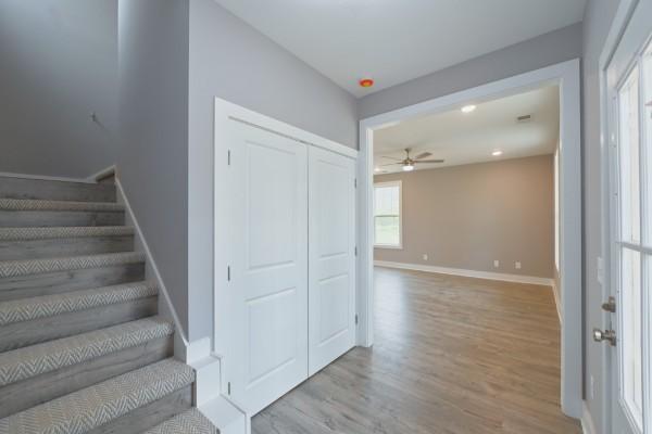 stairs featuring hardwood / wood-style floors and ceiling fan