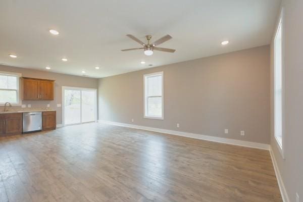 unfurnished living room with ceiling fan, plenty of natural light, and light hardwood / wood-style floors