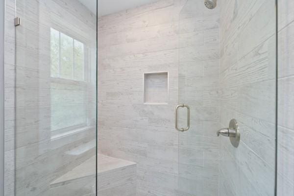 bathroom with a shower with door