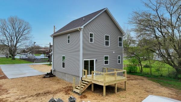 back of property with a wooden deck and a patio area