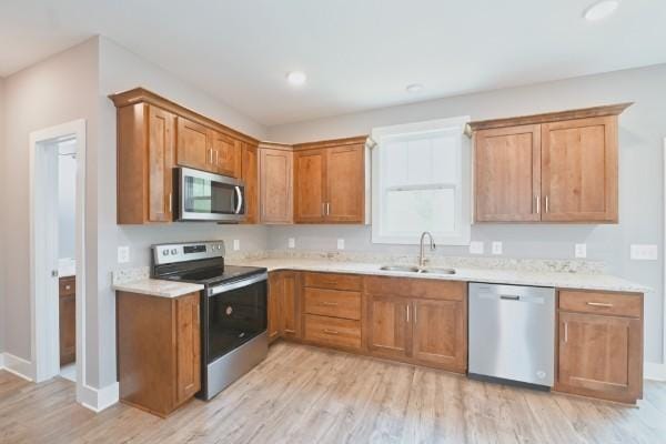 104A N St, Portland, TN 37148 - kitchen with appliances with stainless steel finishes, a sink, light wood-style floors, light countertops, and brown cabinets
