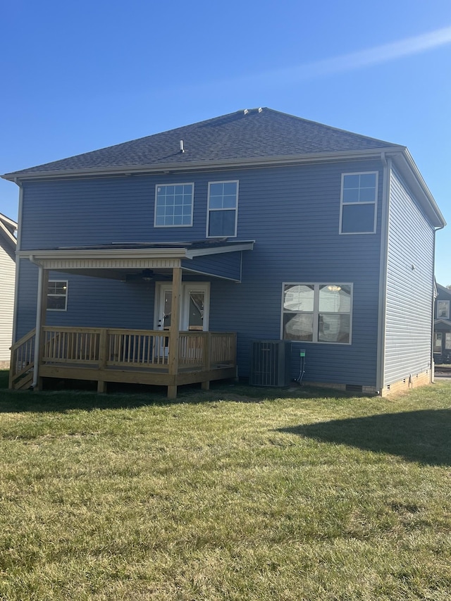 back of property with a wooden deck, cooling unit, and a lawn