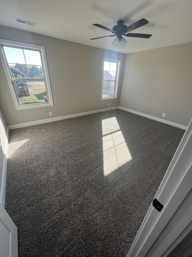 carpeted spare room featuring ceiling fan