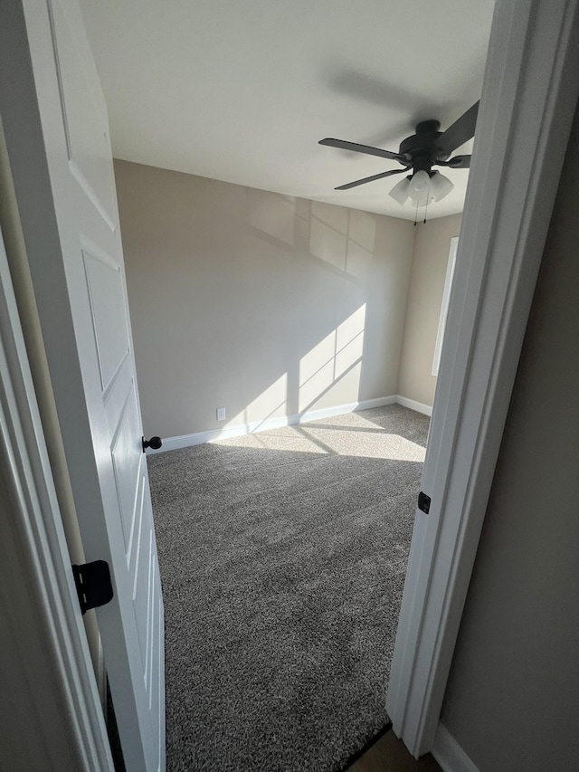 carpeted spare room featuring ceiling fan