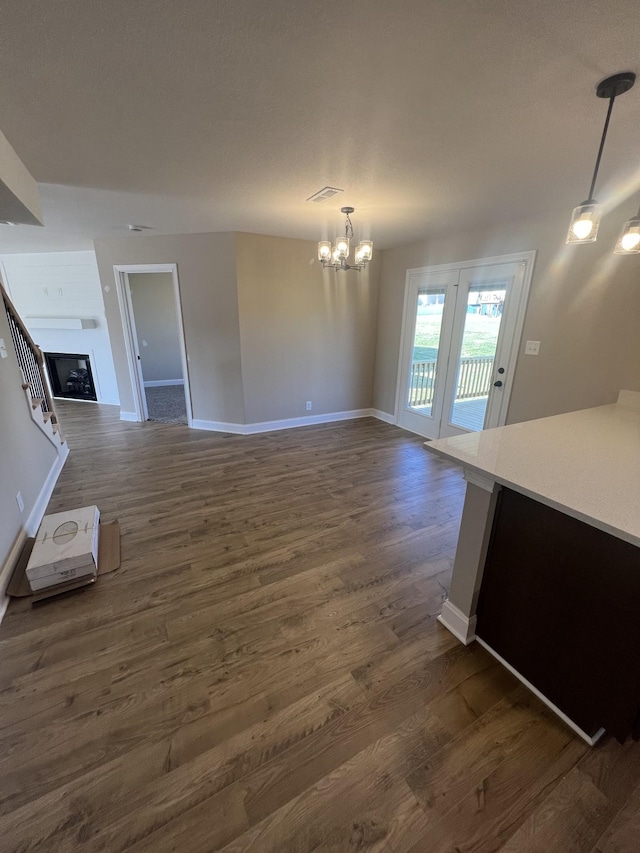 unfurnished living room featuring dark hardwood / wood-style floors and a notable chandelier