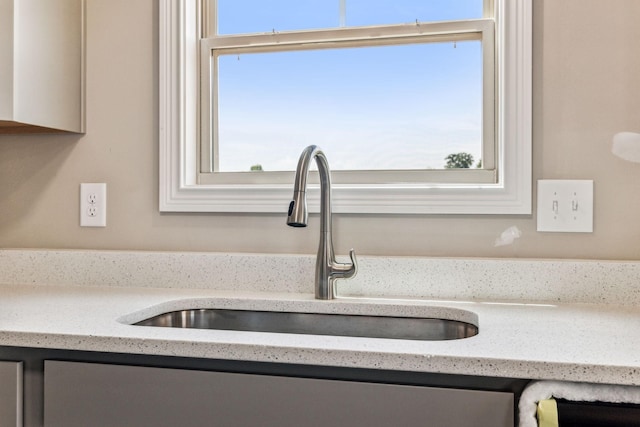 details featuring light stone counters and a sink