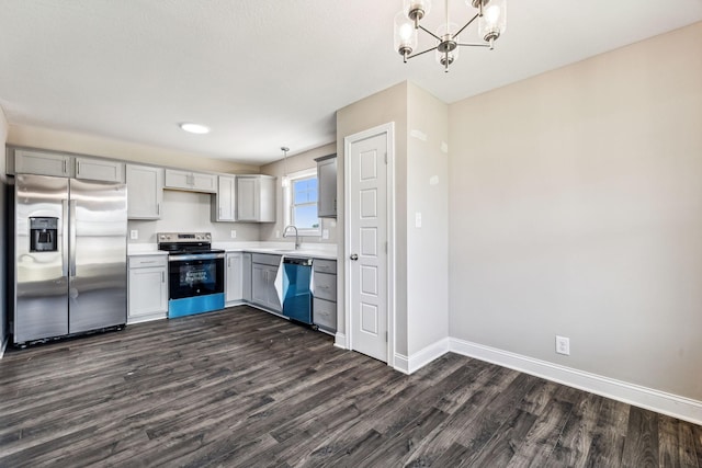 kitchen featuring gray cabinets, a sink, appliances with stainless steel finishes, light countertops, and baseboards