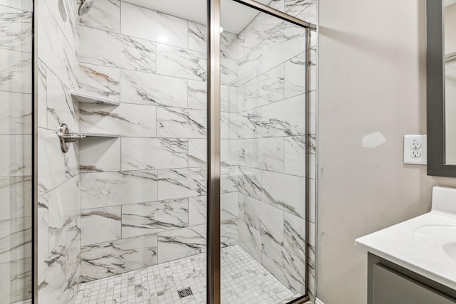 bathroom featuring a marble finish shower and vanity