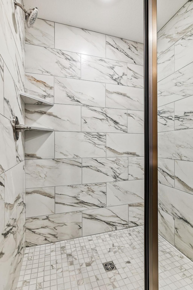 interior details featuring a tile shower