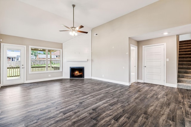 unfurnished living room with stairway, baseboards, dark wood finished floors, a fireplace, and vaulted ceiling