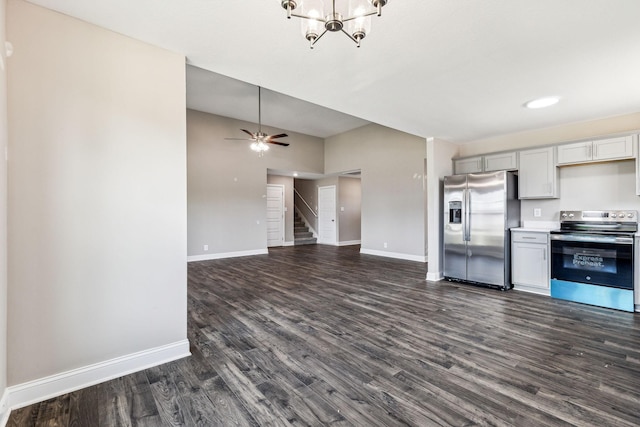 kitchen with baseboards, dark wood-type flooring, appliances with stainless steel finishes, and ceiling fan with notable chandelier